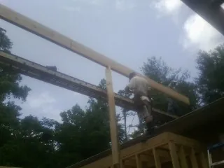 Carpenter setting a ridge beam over a new addition frame — Ice Dam Removal by Roofing Brothers in Crittenden
