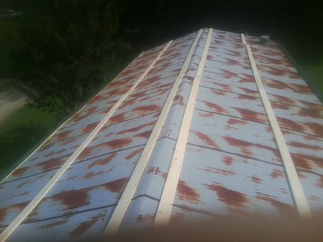 Rusted metal roof panels with new wood purlins before replacement — Storm Damage Roof Repair in Crittenden by Roofing Brothers